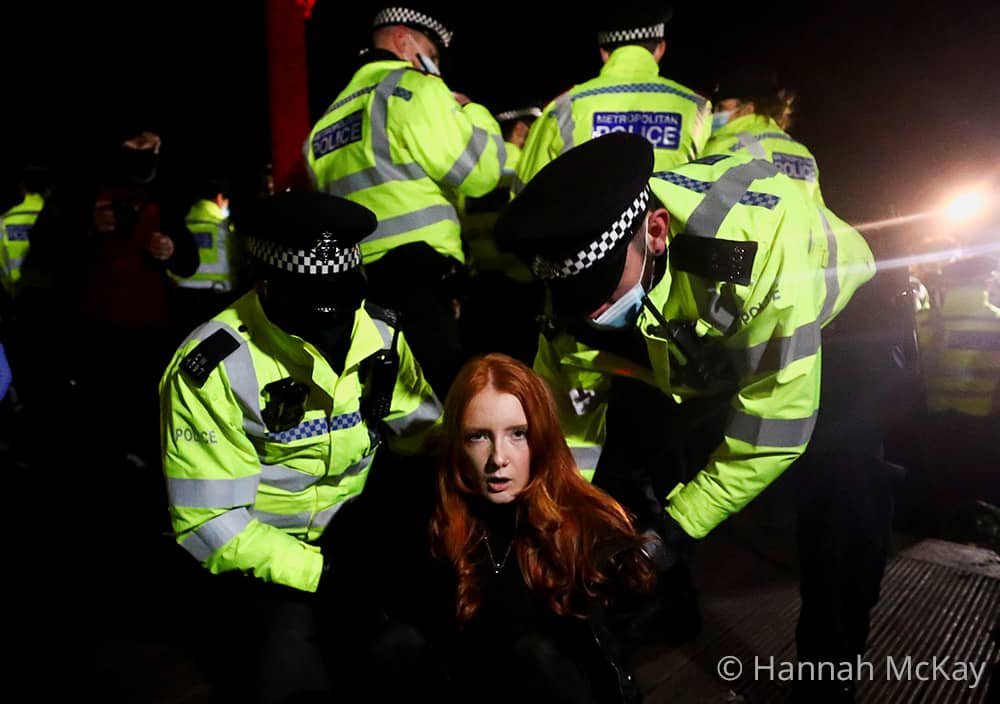 Police officers detain Patsy Stevenson as people gather and protest at a memorial site in Clapham Common Bandstand, following the kidnap and murder of Sarah Everard, in London. 13 March 2021. © Hannah Mckay